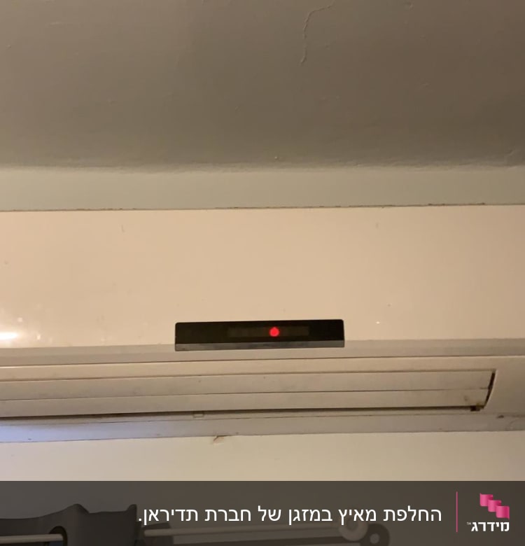 מזגן קיר לבן עם תצוגה דיגיטלית אדומה